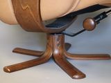 a brown leather reclining chair with a wooden base