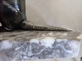 a statue of a cat sitting on top of a marble table