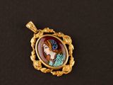 un pendentif plaqué or représentant le portrait d'une femme en robe bleue