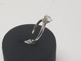 an image of a diamond ring sitting on top of a black ring holder