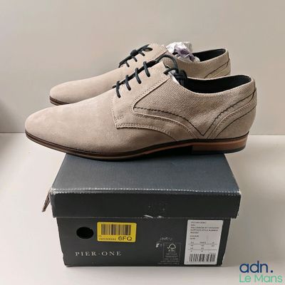 quelqu'un porte une paire de chaussures posées sur une boîte