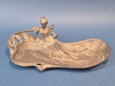 une image représentant une assiette en argent sur laquelle figure une dame