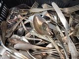 a basket full of silver spoons and spoons in it