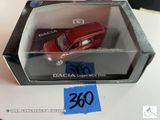une petite voiture rouge dans une boîte posée sur une table