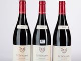 trois bouteilles de vin rouge posées côte à côte sur une table