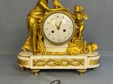 a gold clock that is sitting on a table next to a key