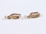 pair of pearl and gold earrings on a white background
