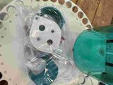 a plastic snowman sitting on top of a table next to a green blow dryer