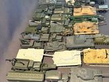 a lot of toy military vehicles and tanks on a table