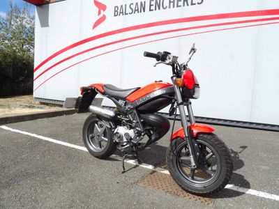 une moto rouge garée sur un parking à côté d'un camion blanc