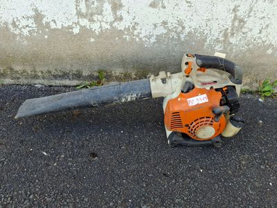 a chainsaw that is sitting on the ground next to a wall