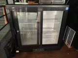 an image of a glass door refrigerator in a kitchen