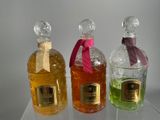 three bottles of perfume are lined up on a clear shelf