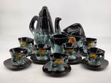 a black and green tea set on a white table