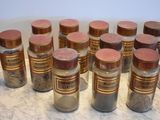 many jars of spices sitting on a counter top