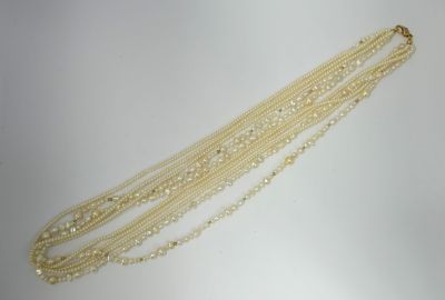 a close up of a necklace with pearls on a white surface