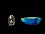 a blue bowl and a silver bowl on a black background
