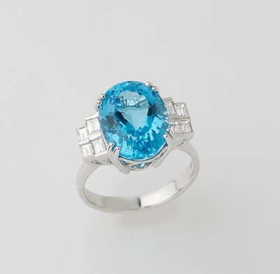 a close up of a ring with a blue topaz stone and diamonds