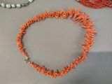 two necklaces and a bracelet sitting on a table