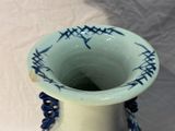 a blue and white vase sitting on a white table