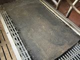 a metal grate on the floor of a cow pen