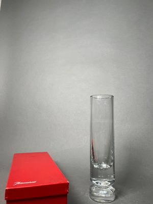a red box next to a tall glass on a table