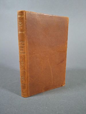 un vieux livre posé sur une table, sur fond gris