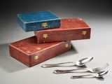 a stack of three boxes with silverware on top of them