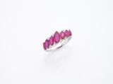 gros plan d'une bague en pierre rose sur une surface blanche