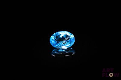 un gros plan d'une boule de cristal bleue posée sur une surface noire