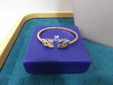 a close up of a gold bracelet on a blue box