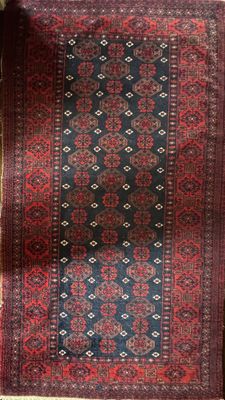 a red and blue rug on a wooden floor next to a window