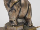 statue of an elephant sitting on a pedestal with a white background