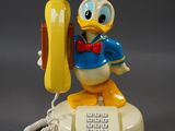 téléphone mickey mouse avec un combiné jaune et un noeud papillon bleu