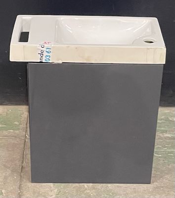 a trash can sitting on the ground next to a black wall