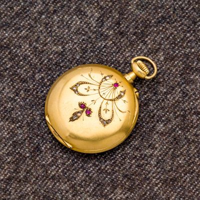 une montre de poche en or ornée d'un diamant rouge