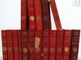 Plusieurs livres rouges sont empilés les uns sur les autres sur une table