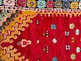 an old rug with a red background and a yellow border