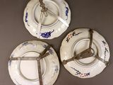 three plates with blue and white designs are hanging on a wall