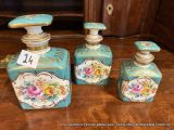 trois flacons de parfum posés sur une table à côté d'un meuble