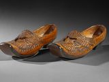 pair of wooden clogs with carved design on the toes