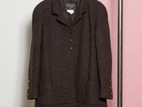grey jacket on a hanger in front of a pink and white wall