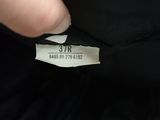 a close up of a person ' s hand holding a label on a black shirt