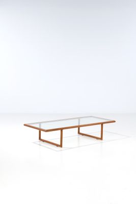 a coffee table with a glass top and wooden legs