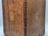 an old book with a brown leather cover and gold trim