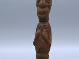 an old wooden figurine of a man with a bird on his shoulder