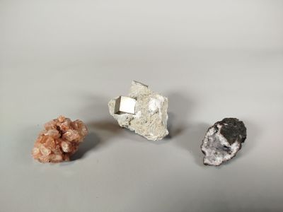 three different types of rocks and crystals on a white surface