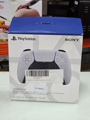 packaging of a sony playstation game controller sitting on top of a table