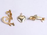 three different types of gold charms on a white surface