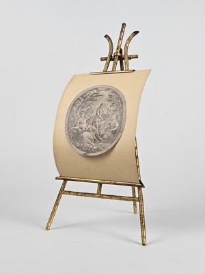un chevalet sur lequel sont posés un tableau et une pièce de monnaie